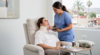 A nurse assisting a recovering patient post-chin liposuction in a comfortable Tijuana recovery room.