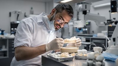 Mexican lab technician crafting zirconia crown under magnification in state-of-the-art dental laboratory