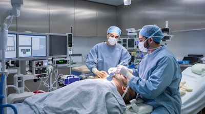 Surgical team preparing diverse patient for dental implant procedure in pre-operative suite