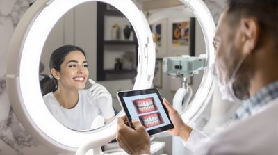 Patient celebrating successful dental implant results with dentist in modern examination room
