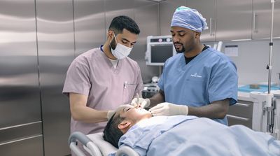Professional surgical team preparing patient for dental implant procedure in sterile operating suite.
