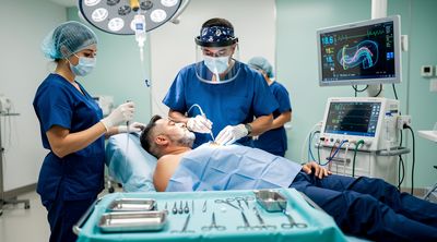 A surgeon performs liposuction for gynecomastia in a modern Mexican operating room.