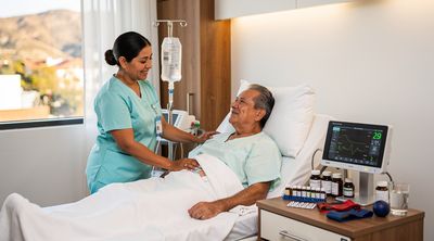 Nurse attends to recovering patient in a well-equipped Mexican hospital room.