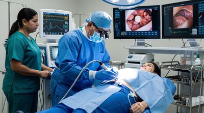 A surgeon performing VASER liposuction in a high-tech operating room on a patient.