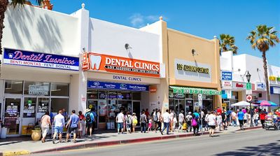 Bustling street scene of dental clinics in Los Algodones, Mexico, attracting tourists.